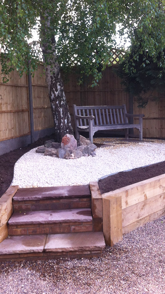 view of the side fencing and sloped patio leading up to the shed